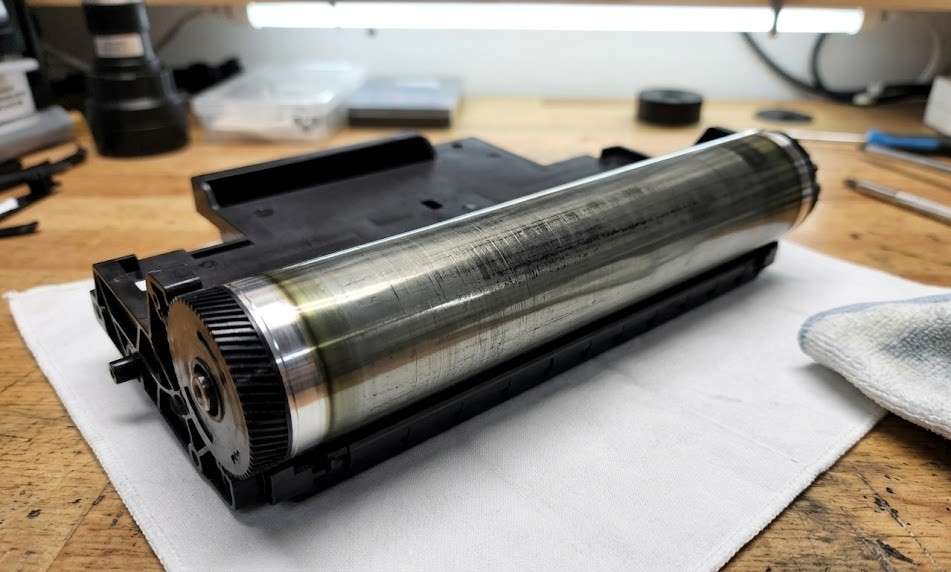 Bộ phận drum máy in laser được đặt trên bàn kỹ thuật để bảo dưỡng